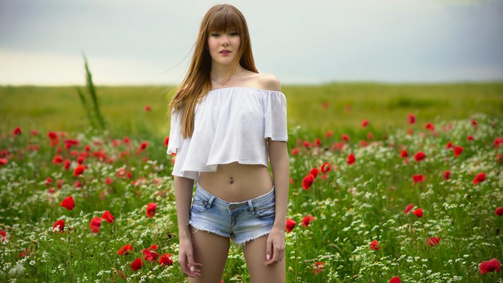 Beautiful Young Woman Standing in a Field of Poppies and Daisies Desktop Wallpaper