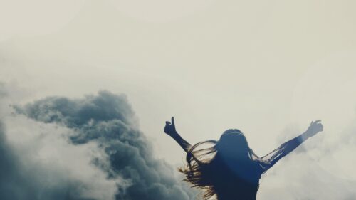 Silhouette of a Woman Celebrating Freedom Above the Clouds 4K Desktop Wallpaper