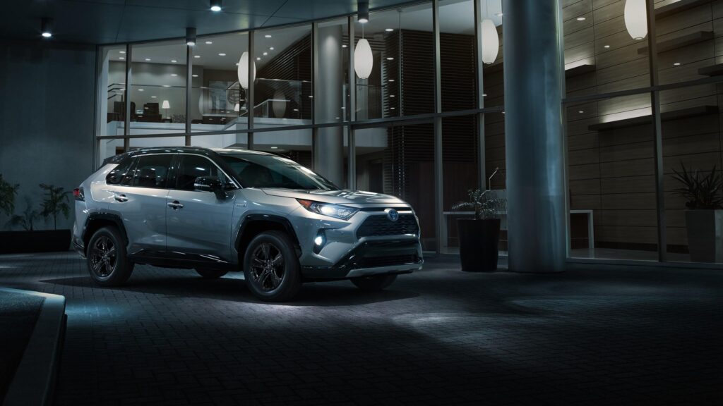 Silver Toyota RAV4 Hybrid SUV Parked Outside Modern Building Desktop Wallpaper
