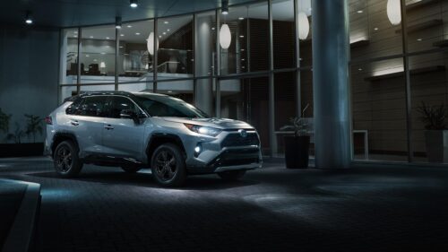 Silver Toyota RAV4 Hybrid SUV Parked Outside Modern Building Desktop Wallpaper