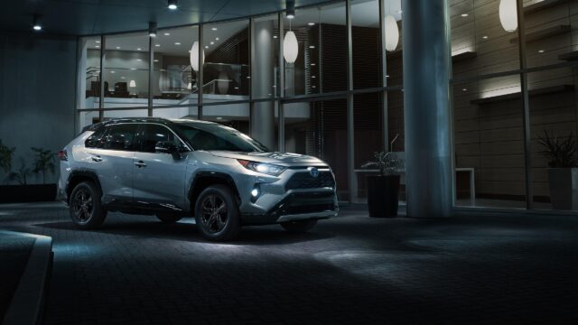 Silver Toyota RAV4 Hybrid SUV Parked Outside Modern Building Desktop Wallpaper