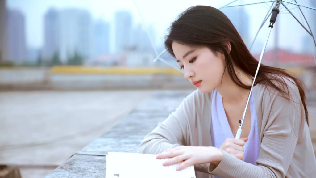 Beautiful Young Woman Reading a Book Under a Clear Umbrella 4K Wallpaper