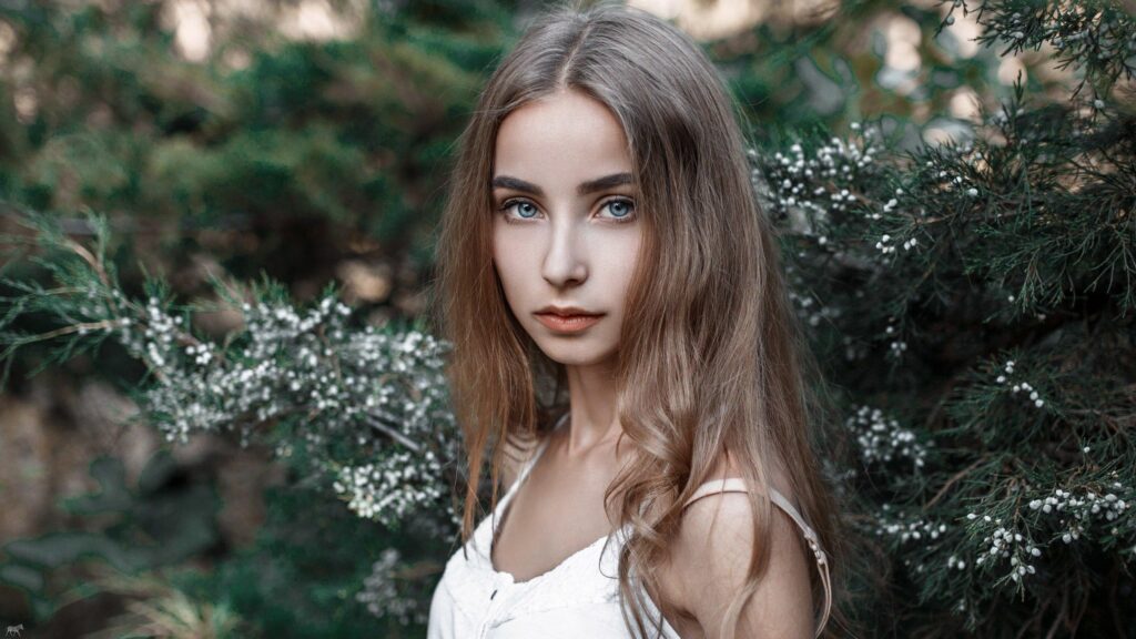 Stunning Portrait of a Young Woman with Blue Eyes in Nature Desktop Wallpaper