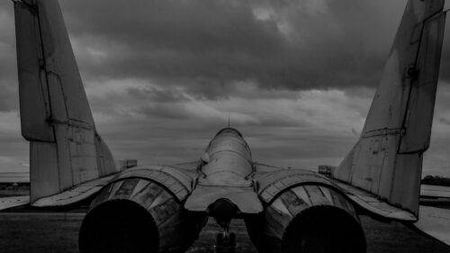 Dramatic Rear View of a Fighter Jet Under Ominous Storm Clouds Desktop Wallpaper