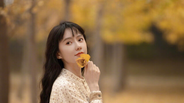 Beautiful Young Woman Holding a Dried Rose in Autumn Forest 4K Desktop Wallpaper